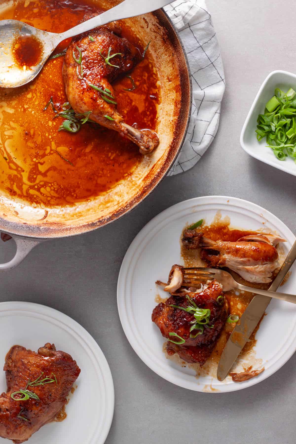 A plate of spicy chicken in a ginger, citrus and soy sauce with a fork taking out a bite.