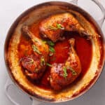 Chicken leg quarters smothered in a spicy ginger, citrus and soy sauce in a large skillet.