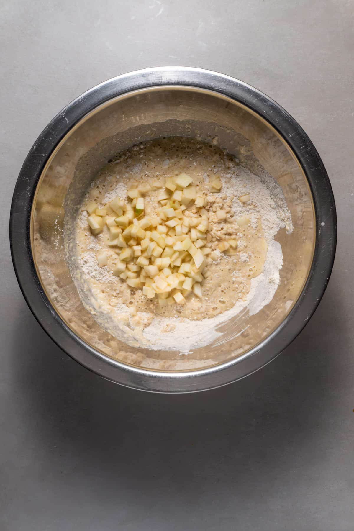 Batter for brown butter apple pancakes in a medium mixing bowl.