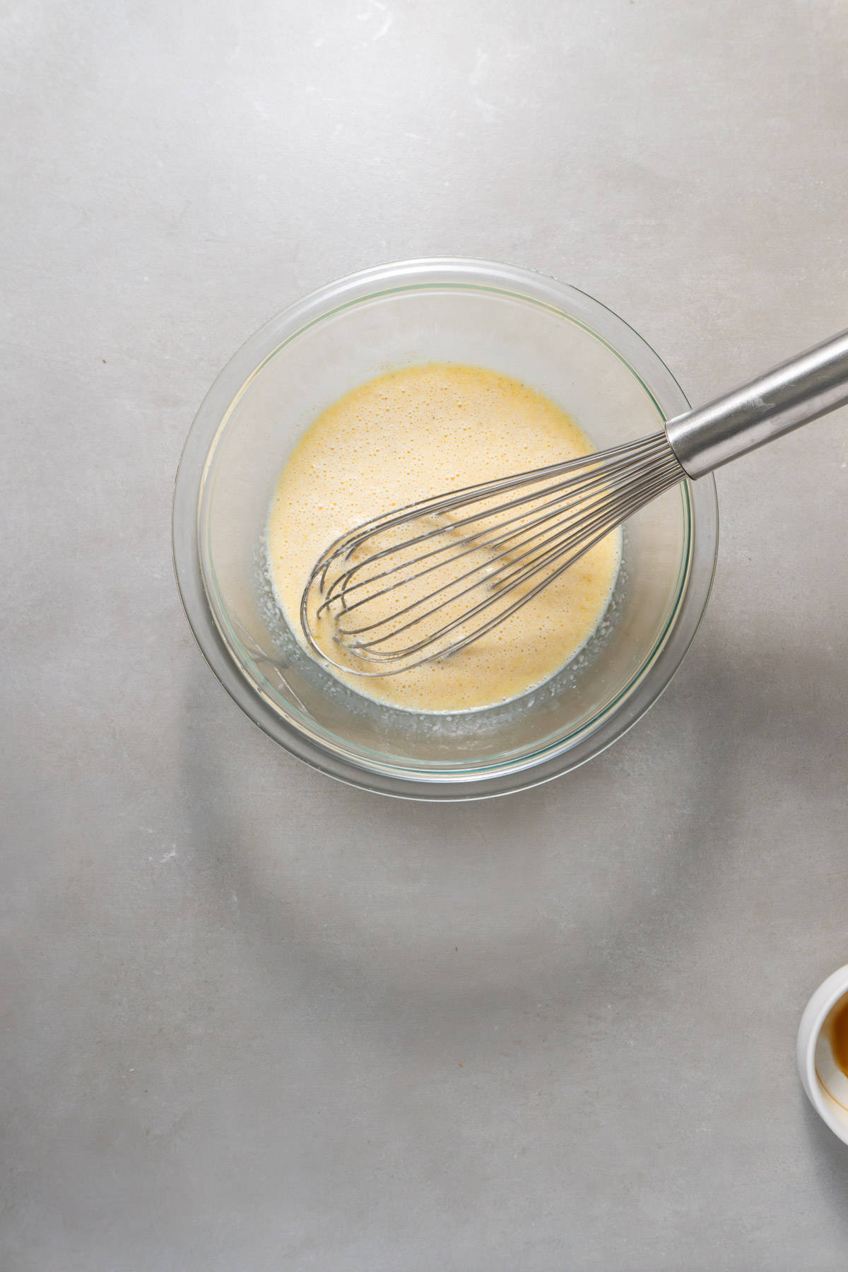 The wet ingredients for brown butter apple pancakes in a medium mixing bowl.