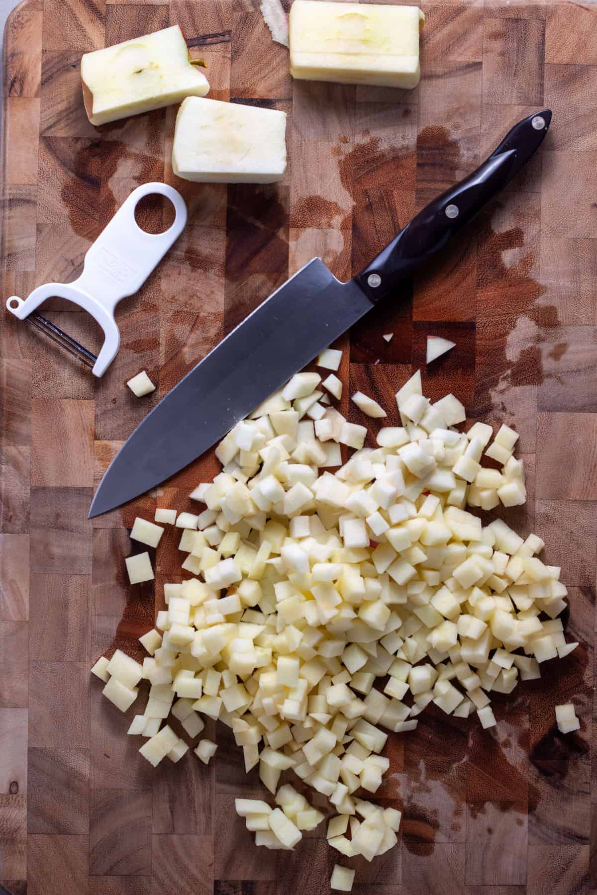 Peeled and diced apples on a cutting board.