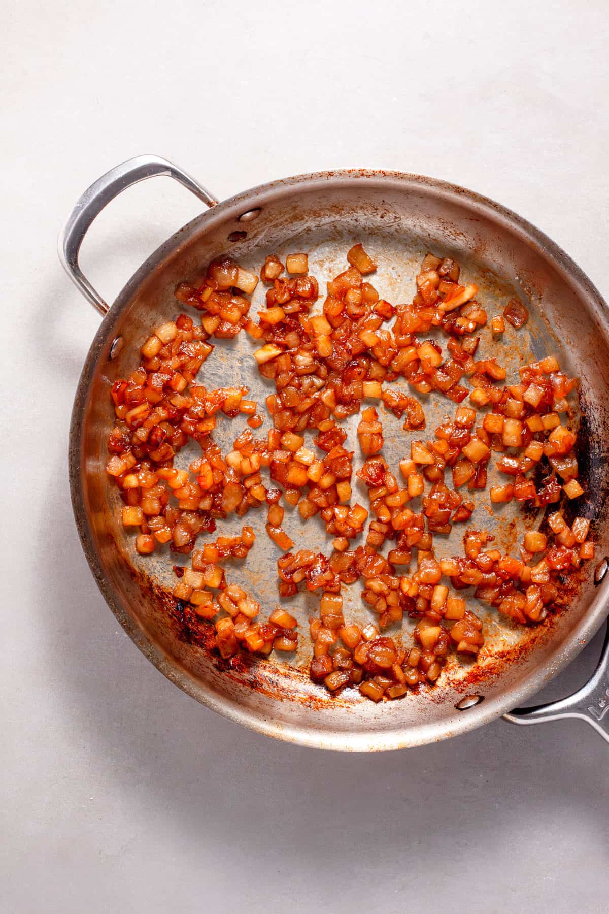 Apples and brown sugar caramelizing in a large skillet.