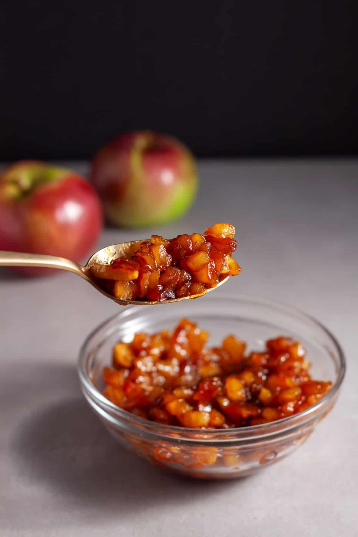 A small bowl of caramelized apples on a gray table.