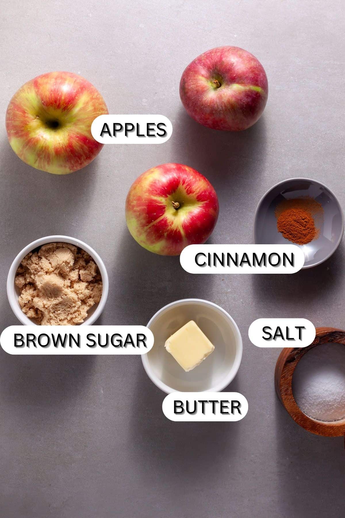 Ingredients for caramelized apples on a gray table.