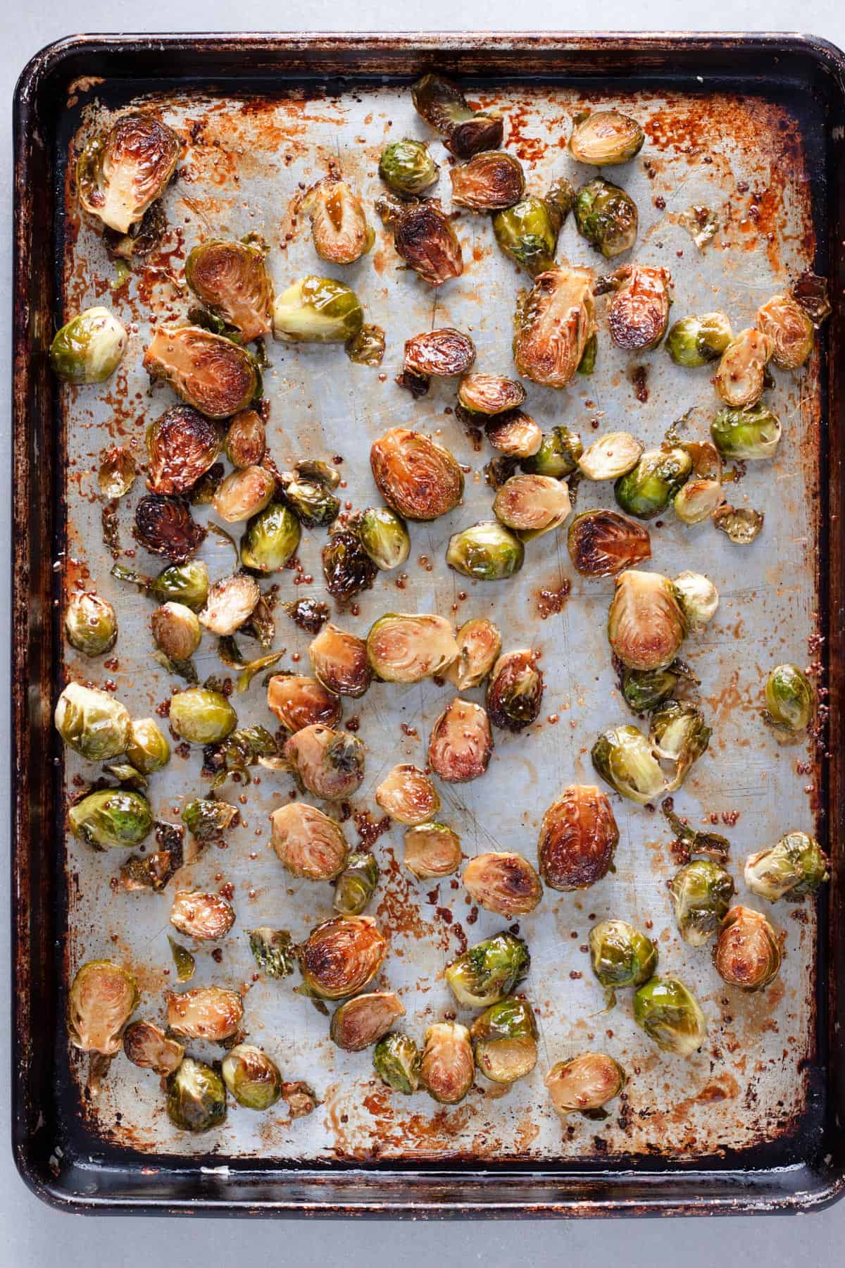 Maple balsamic brussels sprouts on a baking sheet roasted to golden brown.