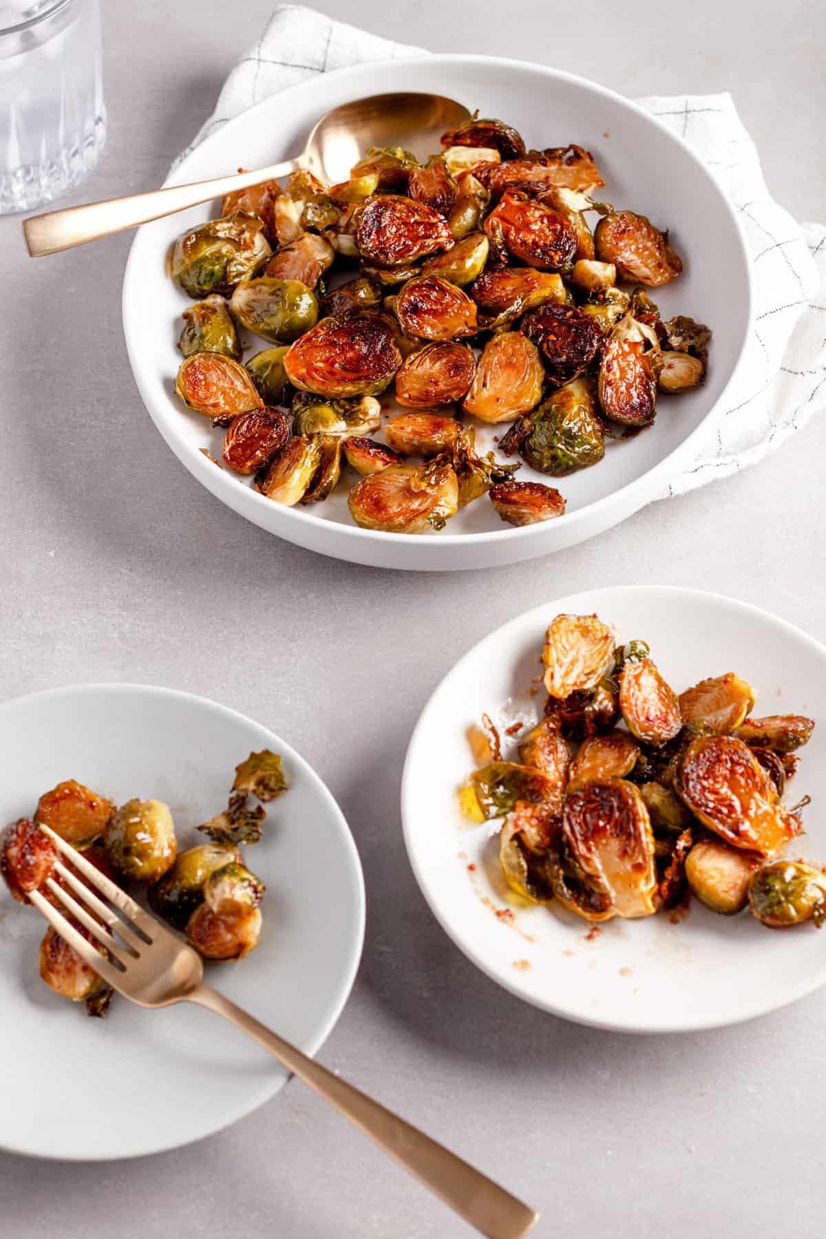 Maple balsamic Brussels sprouts on a serving bowl with a couple small portions to the side.