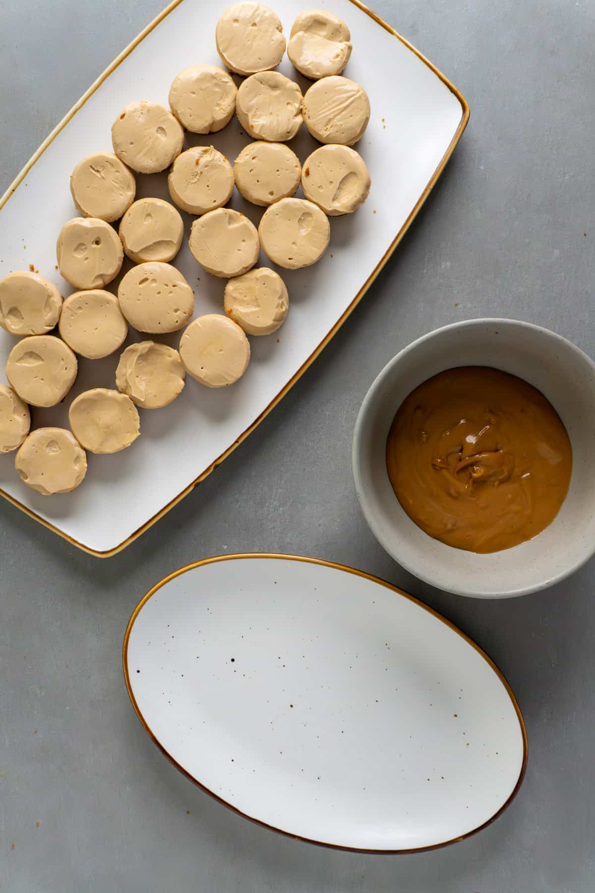 Mini biscoff cheesecakes out of a muffin pan and on a large plate.