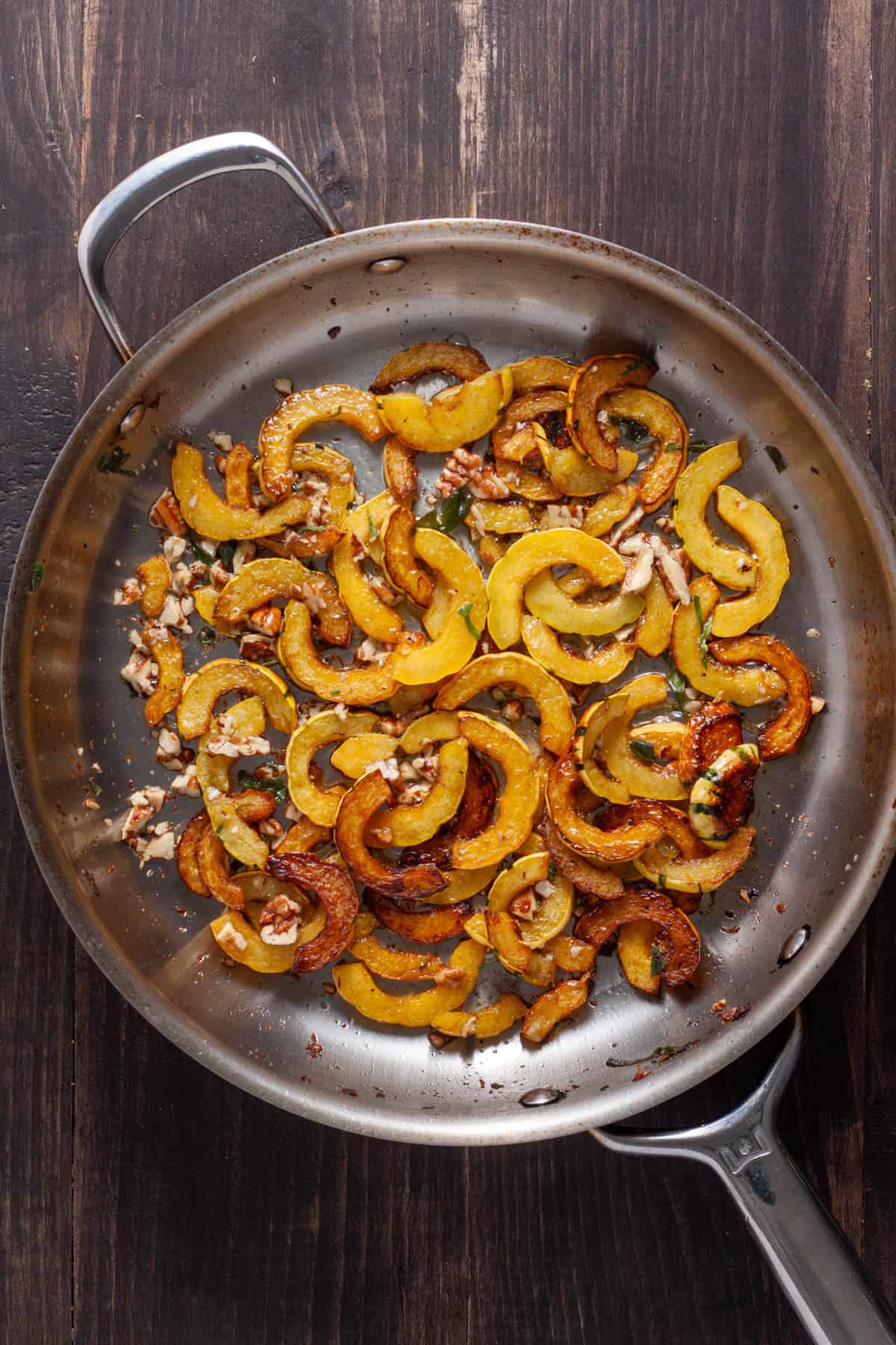 Sliced delicata squash cooked to golden brown in a large skillet.