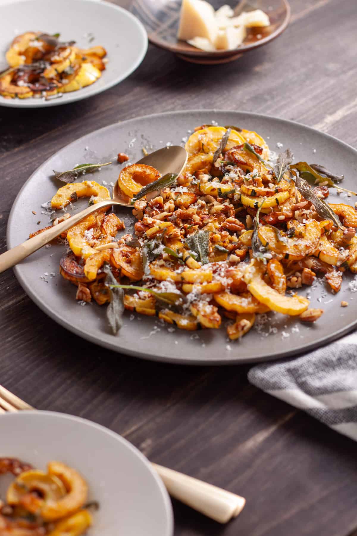 Sauteed delicata squash with crispy sage on a serving platter.