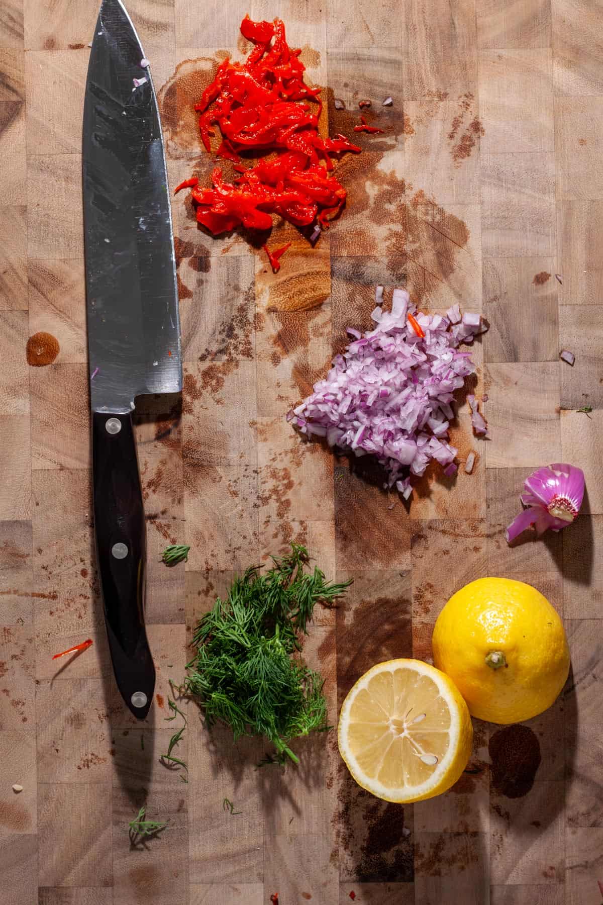 Ingredients for smoked trout salad chopped up on a cutting board.