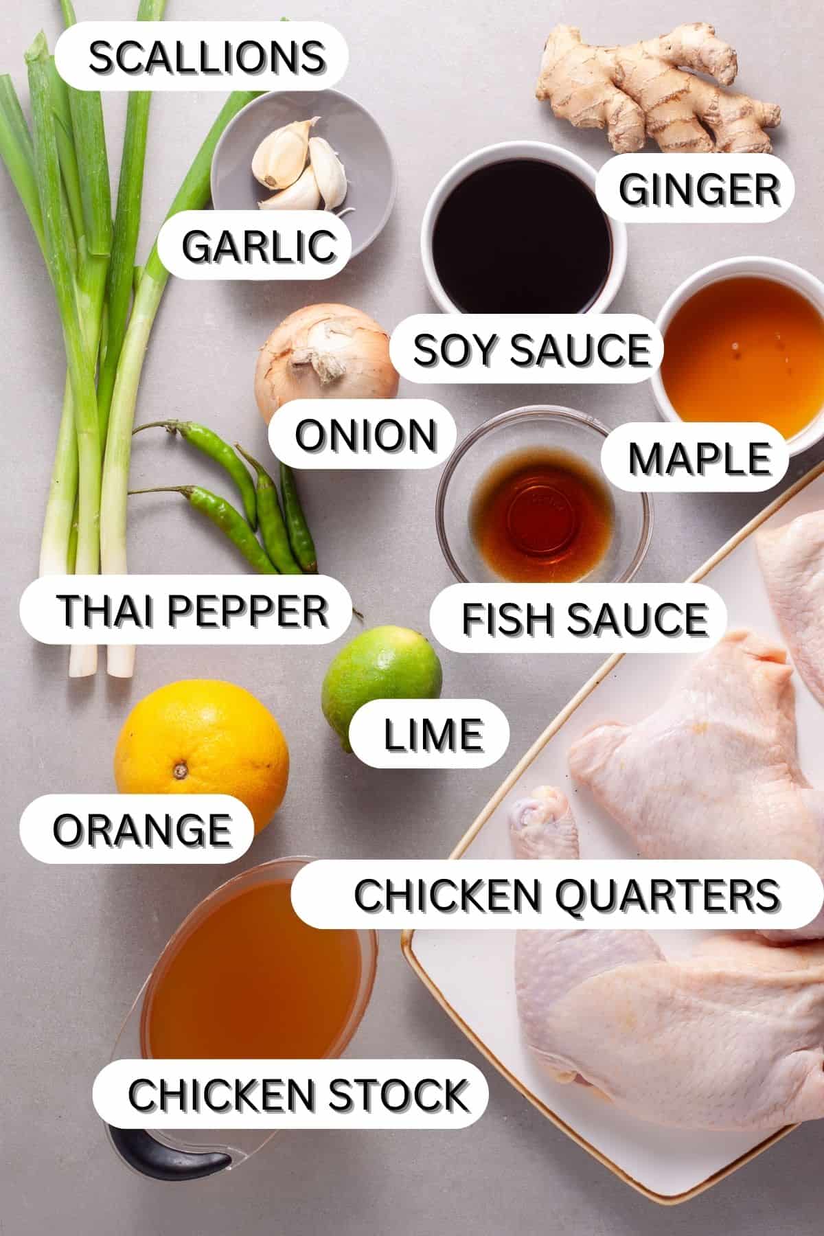 Ingredients for a gray table for a braised spicy chicken quarters with ginger, citrus and soy.