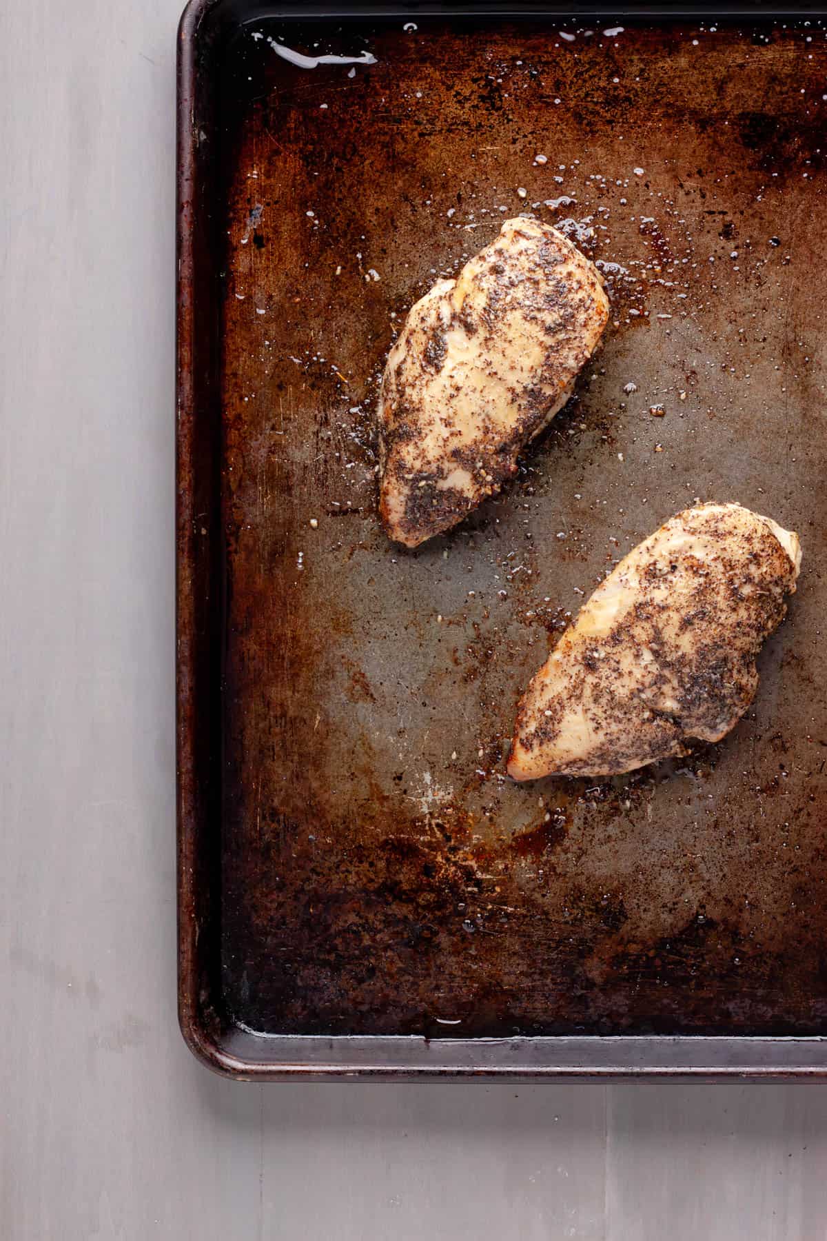 Za'atar chicken breasts on a baking sheet, golden brown.