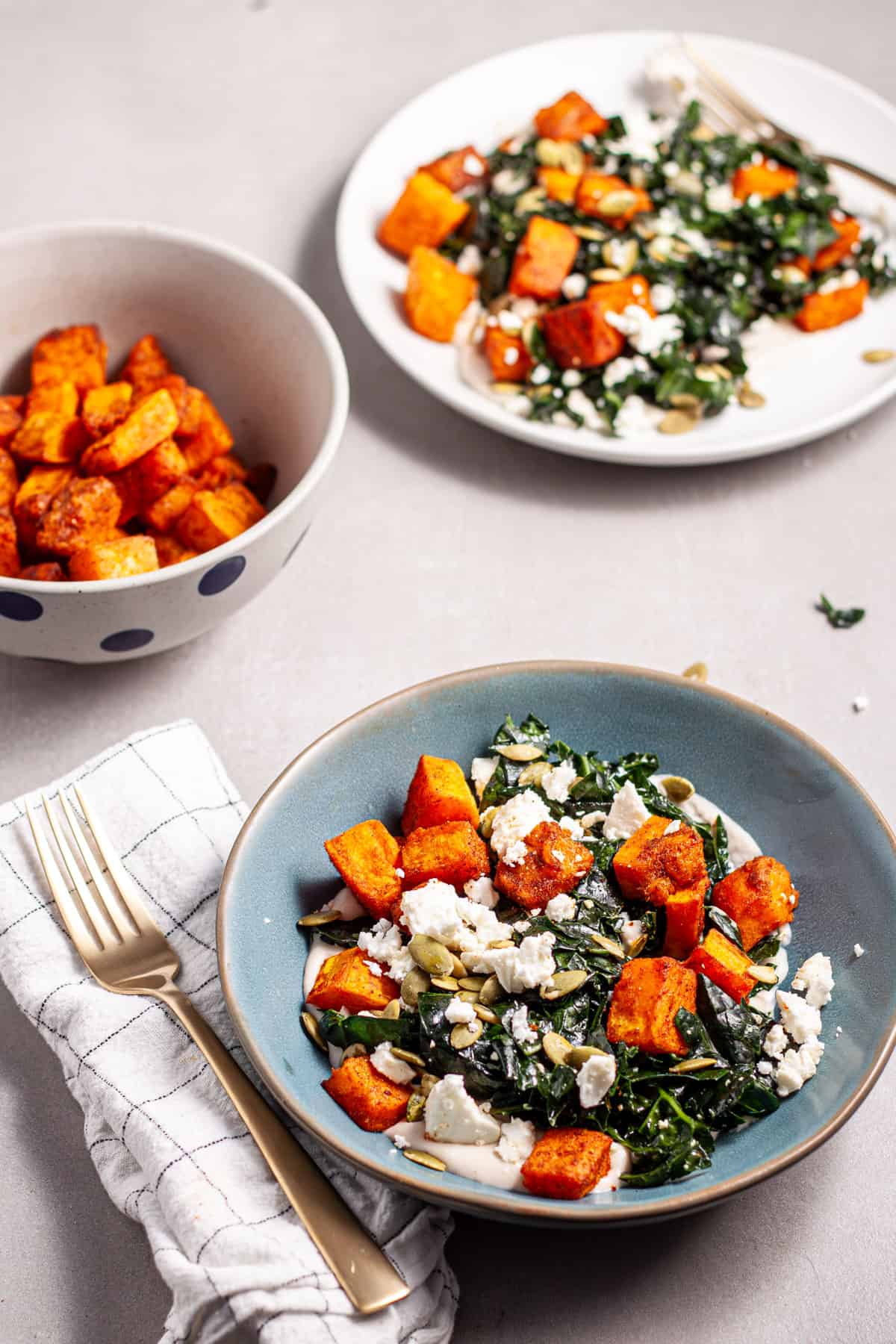 A blue bowl of butternut squash and feta salad.