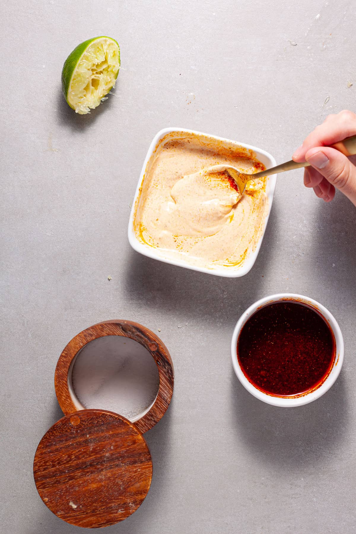 A chili oil getting stirred into sour cream for sheet pan tofu fajitas.