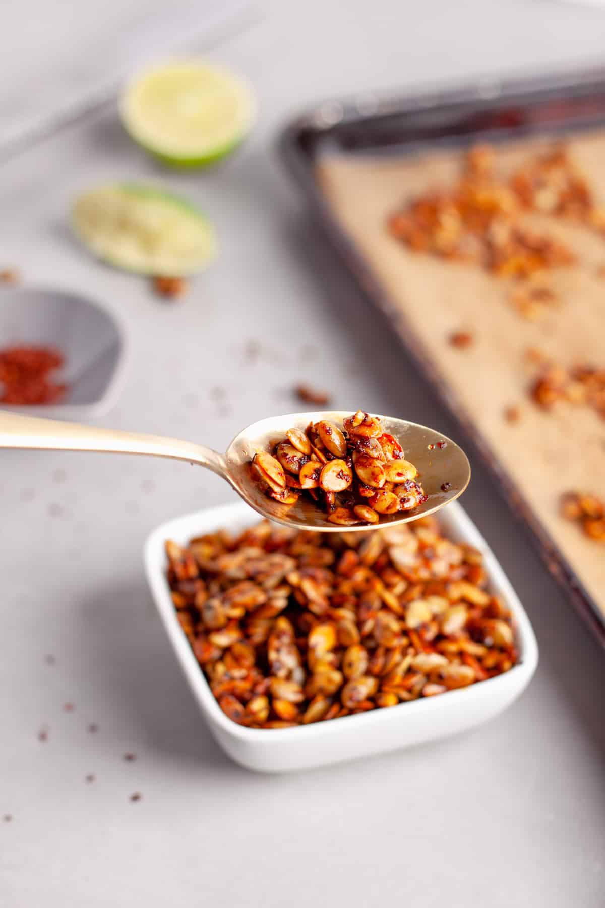 A spoonful of chili lime pepitas in a small bowl.