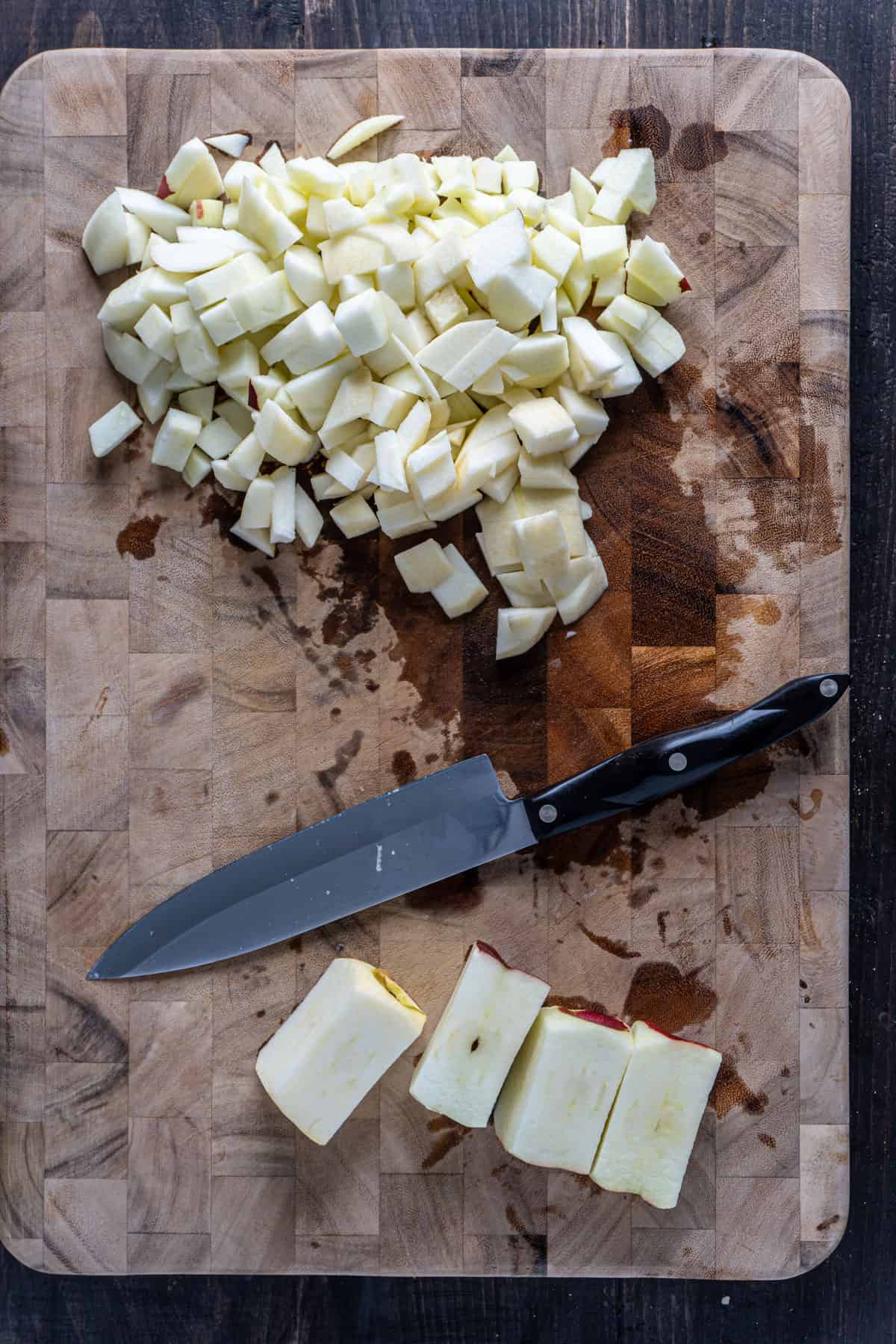 Apples peeled and chopped on a cutting board getting ready to be added to a apple crisp.