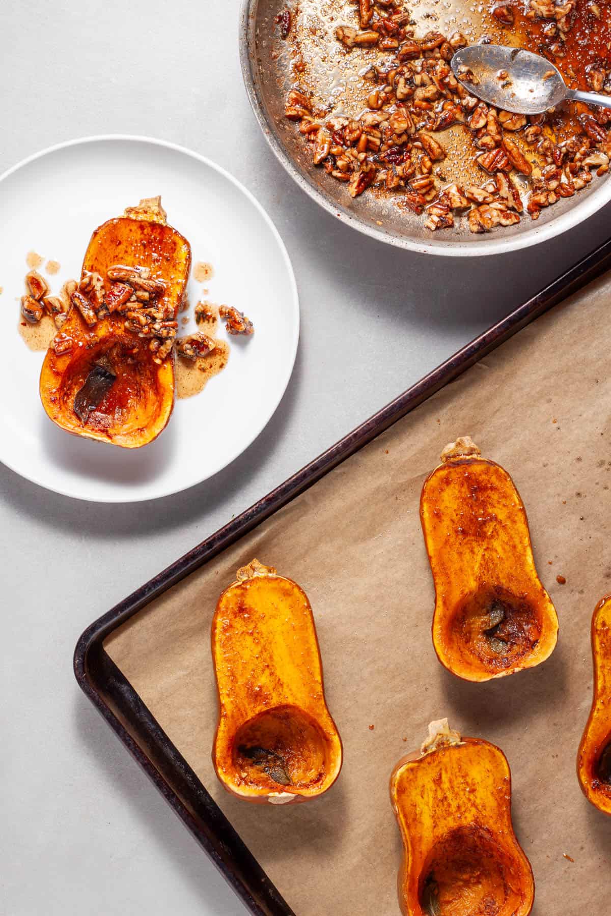 Roasted honeynut squash getting topped with candied maple pecans and sage.