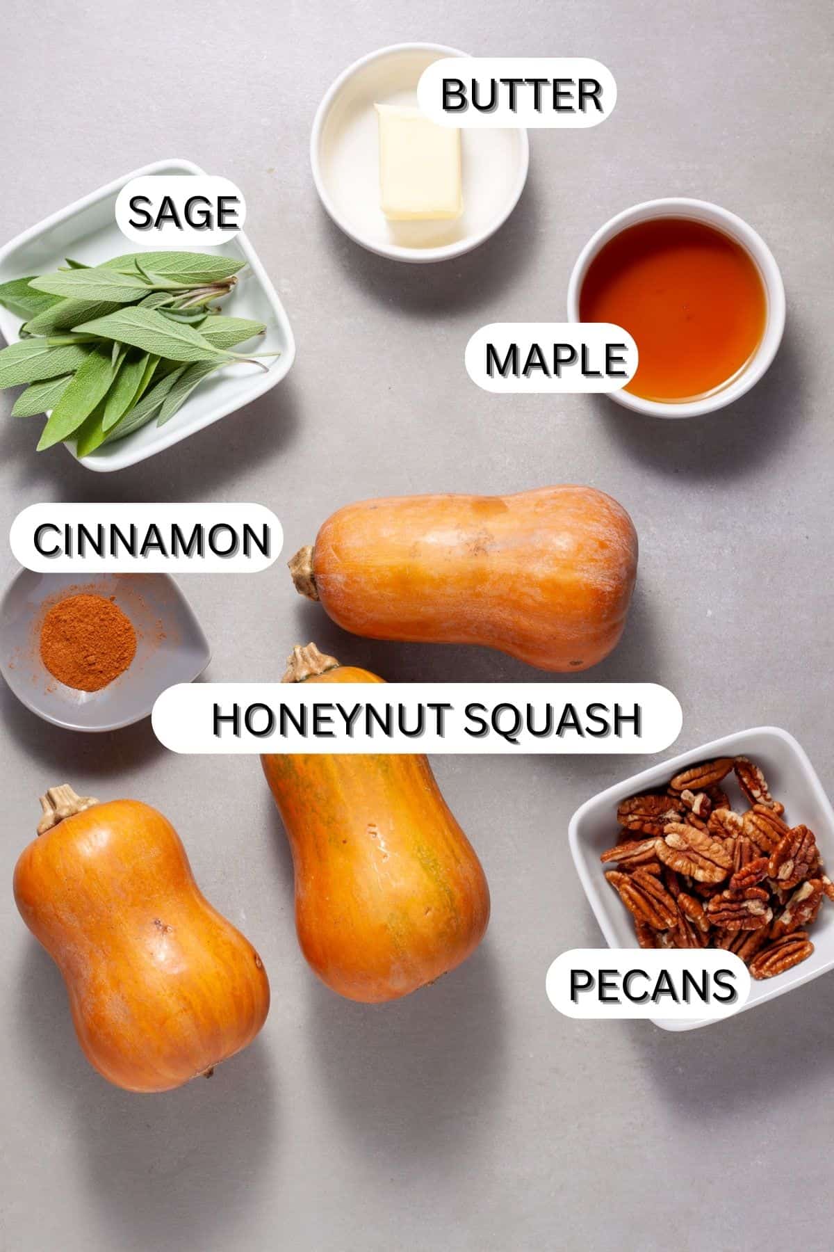 Ingredients for roasted honeynut squash with pecans and sage on a gray table.