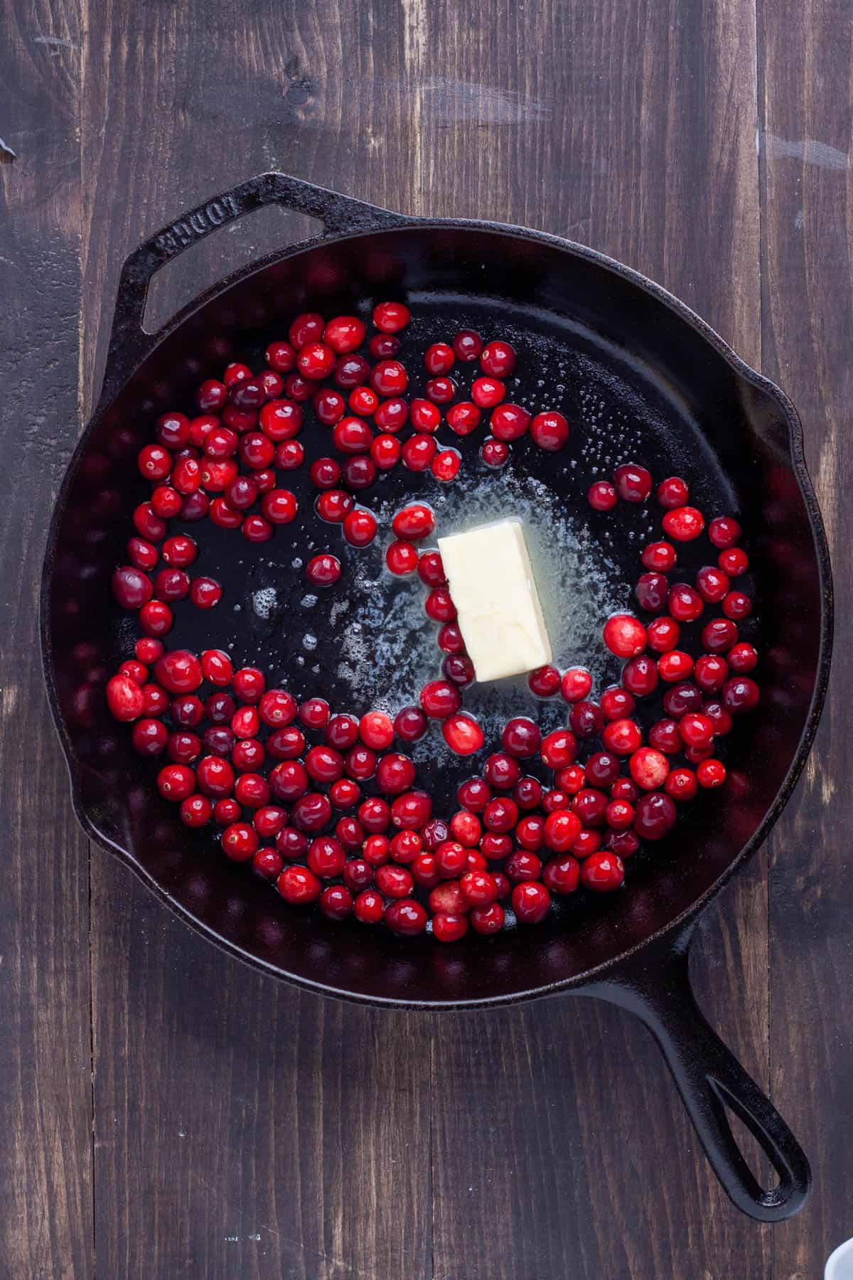 Butter and cranberries in a cast iron skillet.