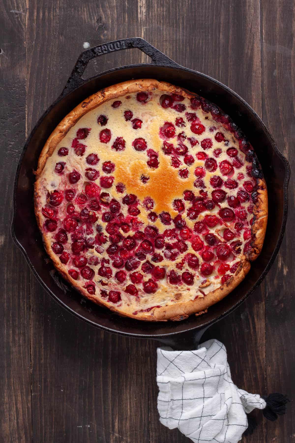 A cranberry Dutch baby in a cast iron skillet just out of the oven.