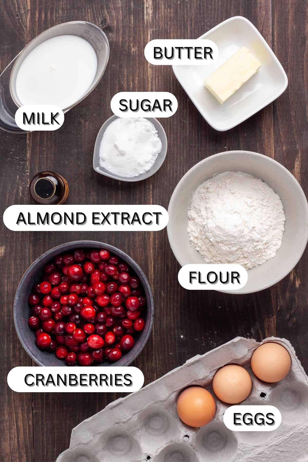 Ingredients for a Cranberry Dutch Baby on a dark table.