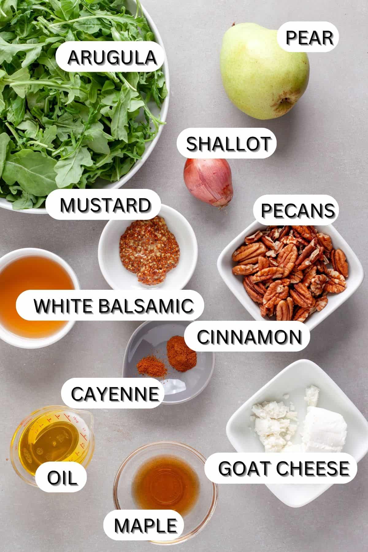 Ingredients for an arugula and pear salad on a gray table.