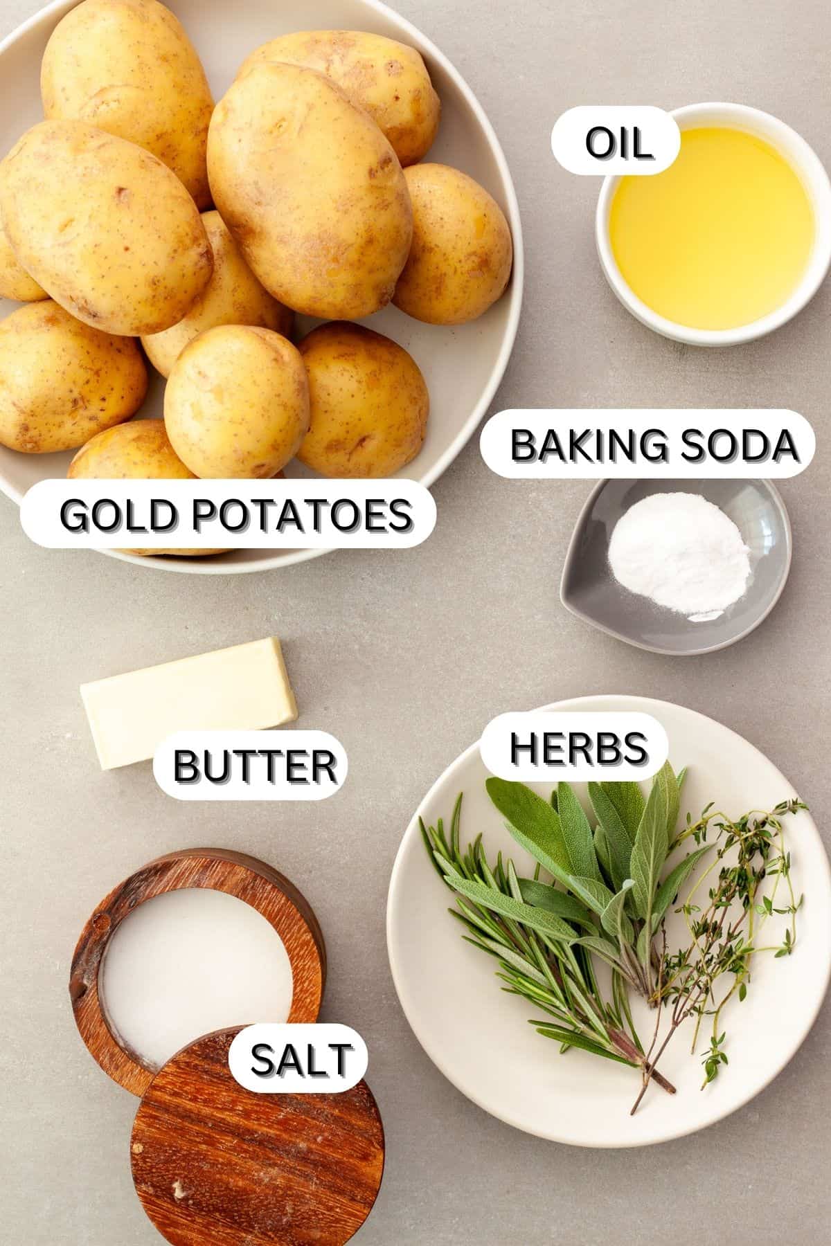 Ingredients for crispy herb roasted potatoes on a gray table.