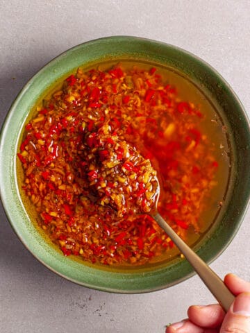 A green bowl with a red spicy chili-lemongrass sauce.