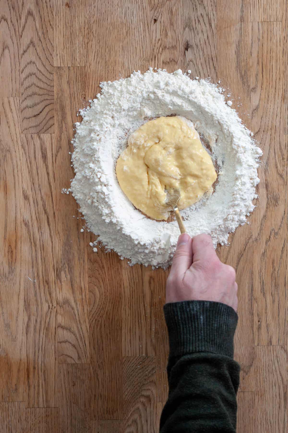 Flour getting incorporated to a beaten egg for homemade fresh pasta.