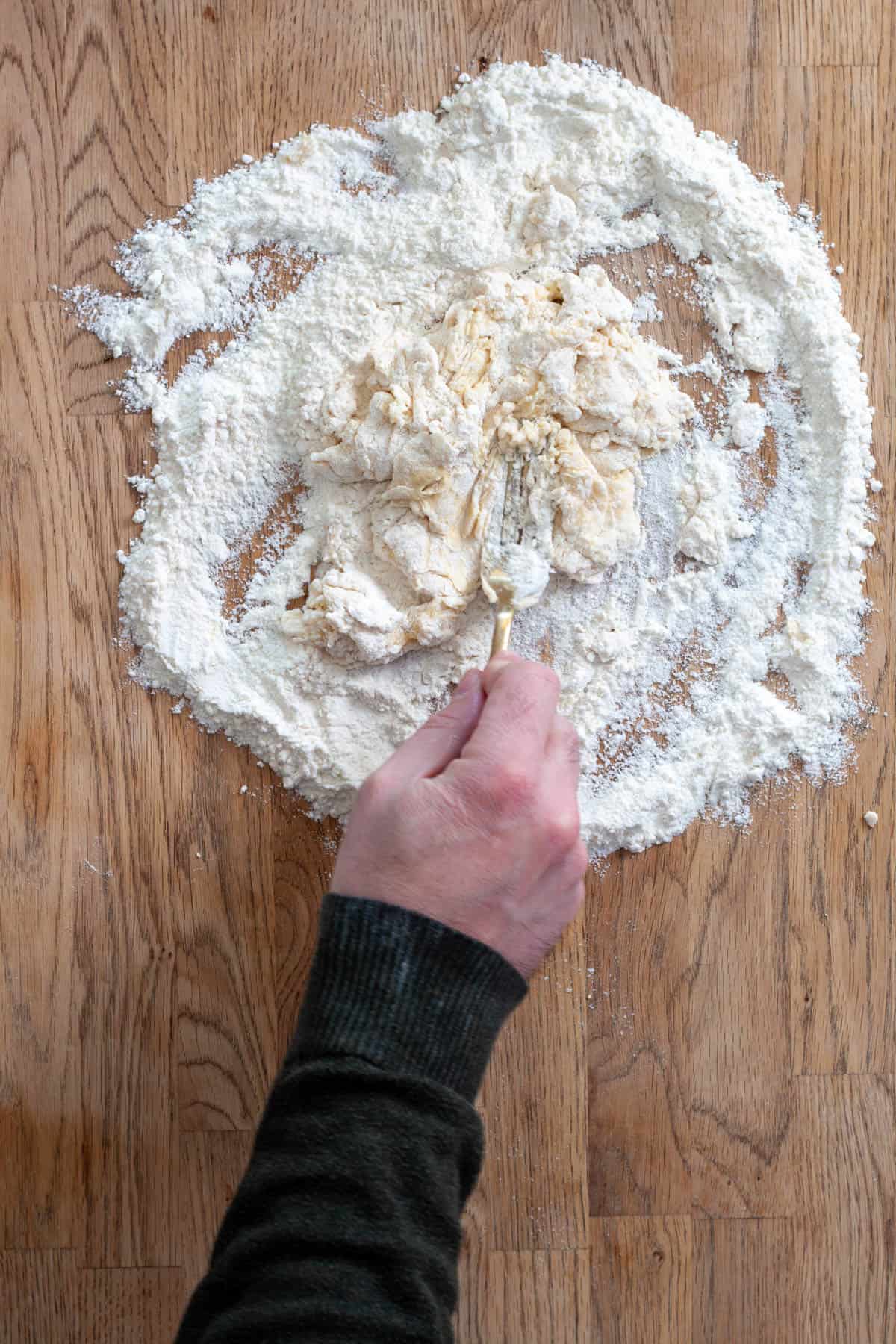 A shaggy dough formed on a countertop for fresh pasta.