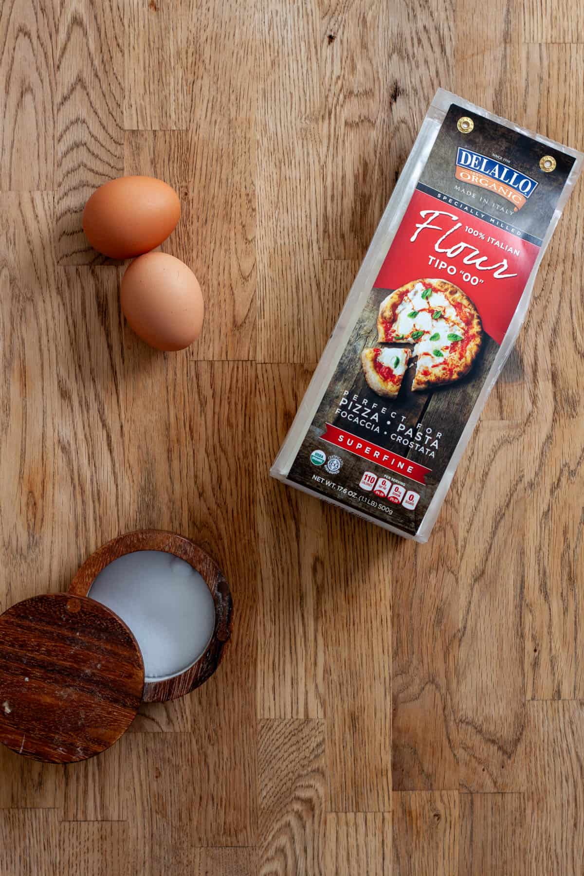 Ingredients for homemade fresh pasta on a butcherblock countertop.