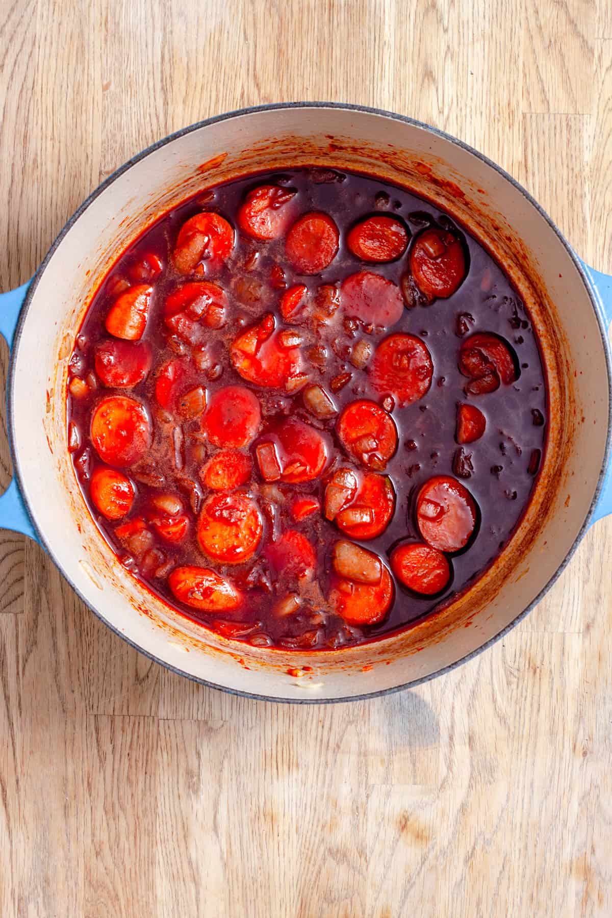 Braising liquid reducing in a Dutch oven for braised beef shanks.