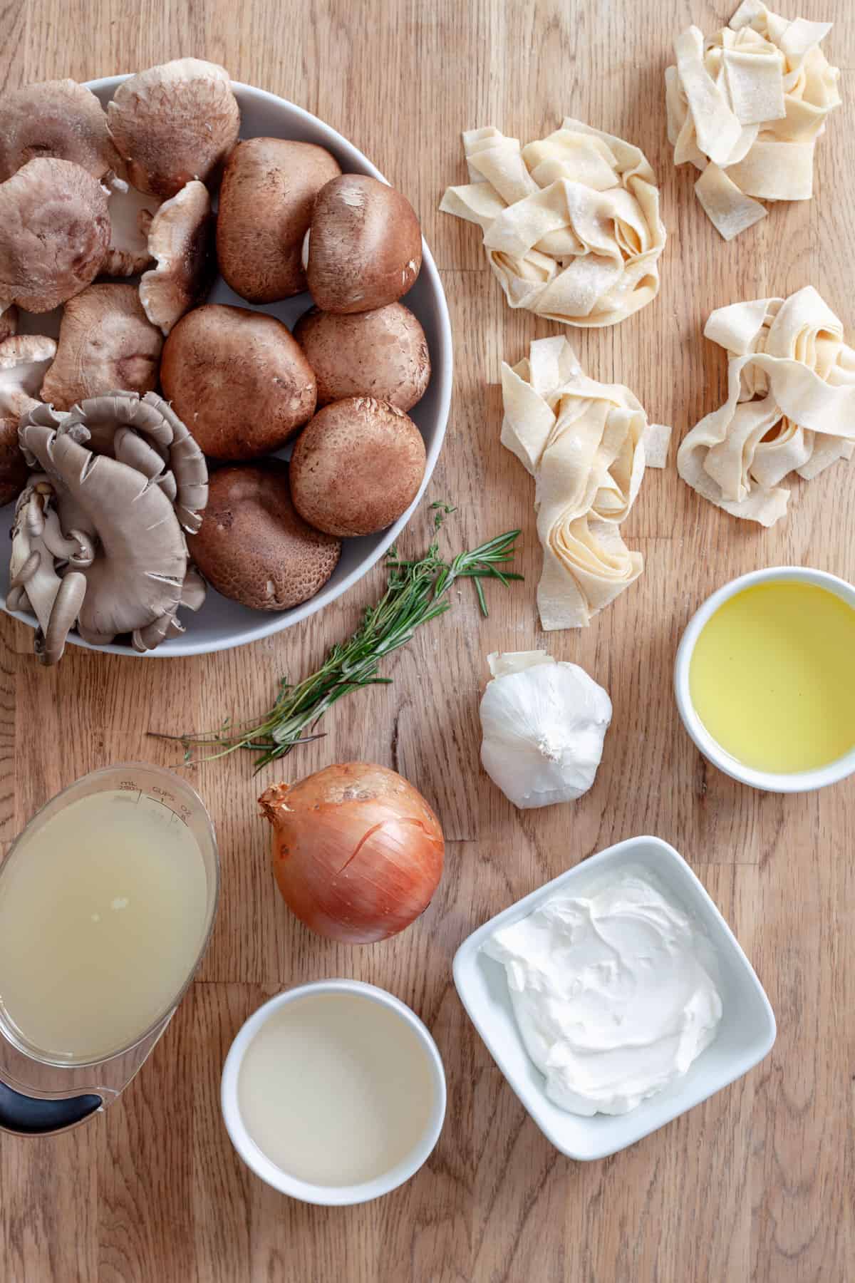 Ingredients for mushroom pappardelle on a butcherblock countertop.