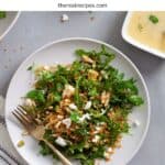 A serving of arugula and crispy quinoa salad on a gray table.