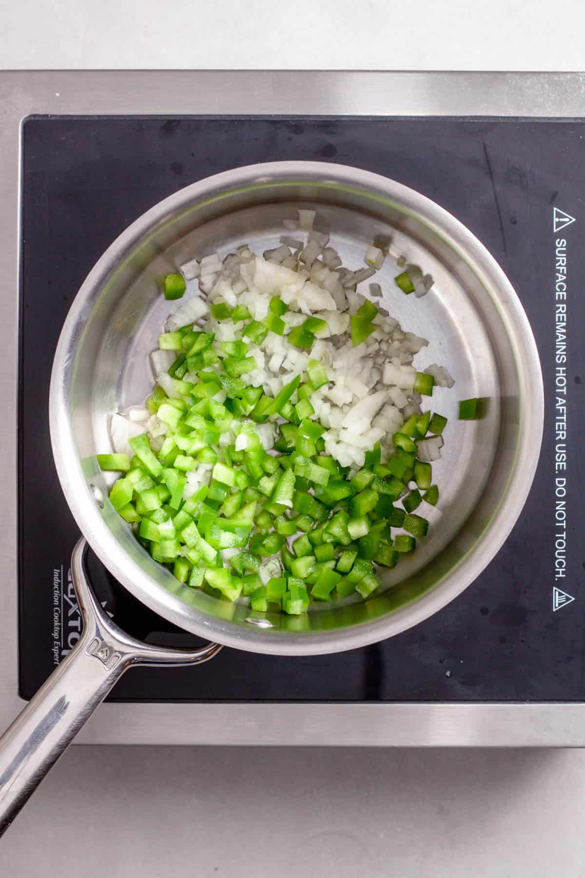 Onions and peppers cooking in a saucepan for bulgur pilaf.