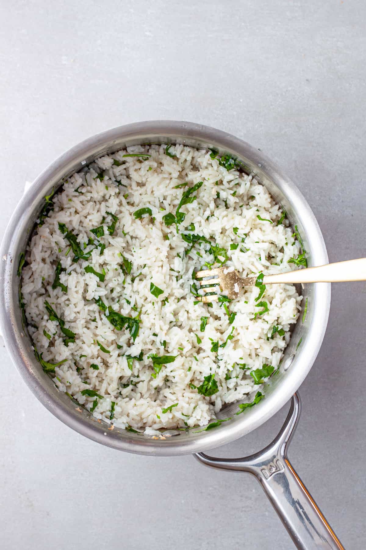 Chopped cilantro fluffed into cooked coconut rice.