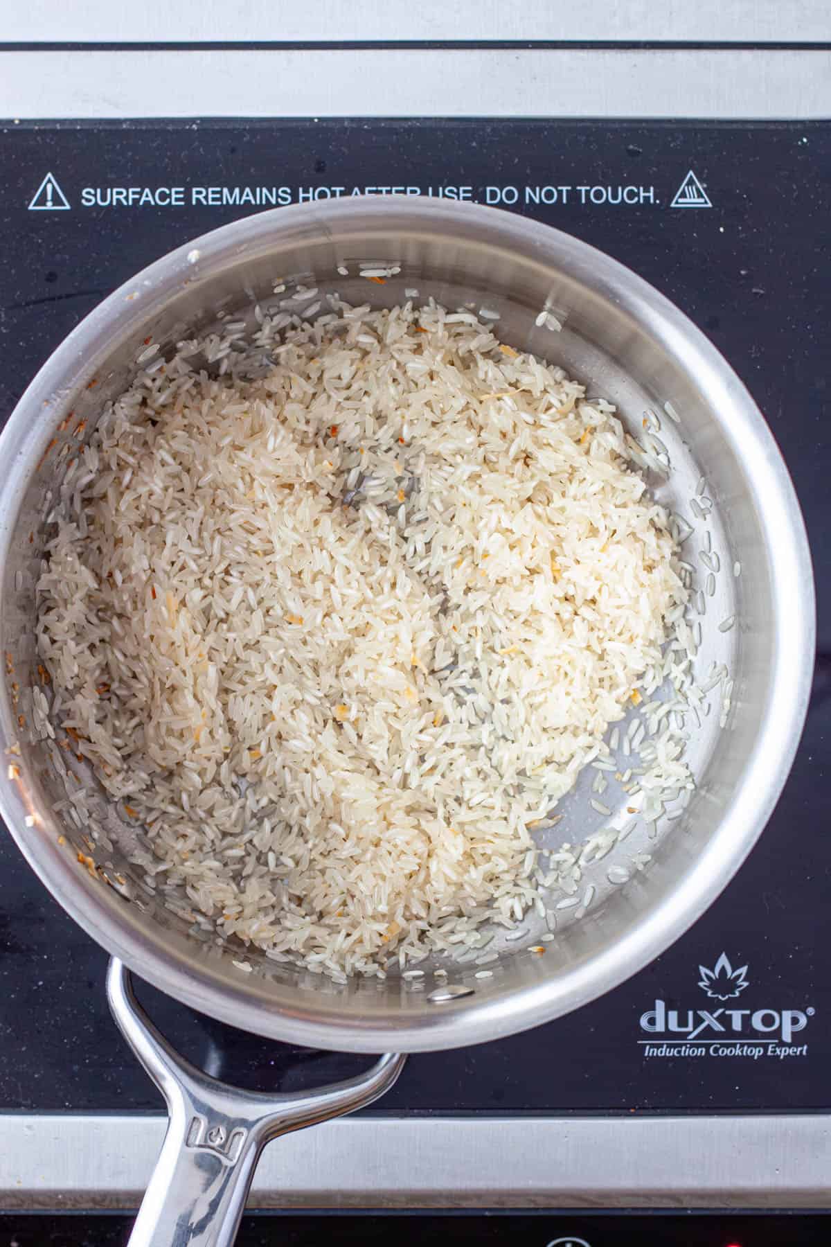 White rice toasting in a medium saucepan.