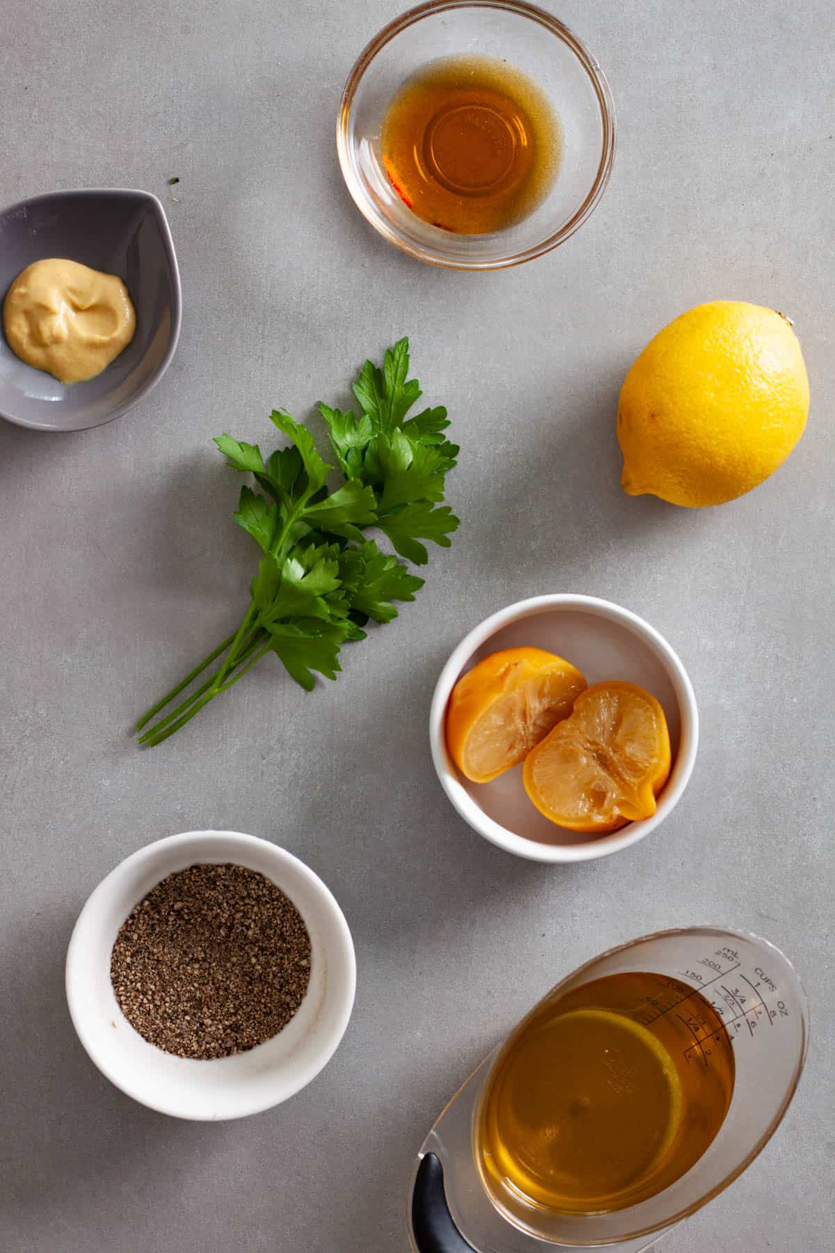 Ingredients for a preserved lemon vinaigrette on a gray table.