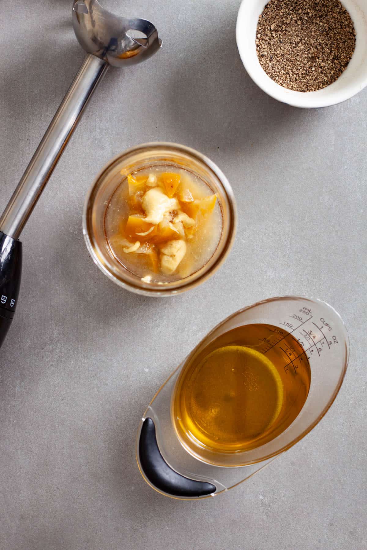 Chopped preserved lemons, dijon mustard, lemon juice and maple syrup in a glass mason jar.