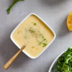 A small white bowl of preserved lemon vinaigrette topped with chopped parsley.