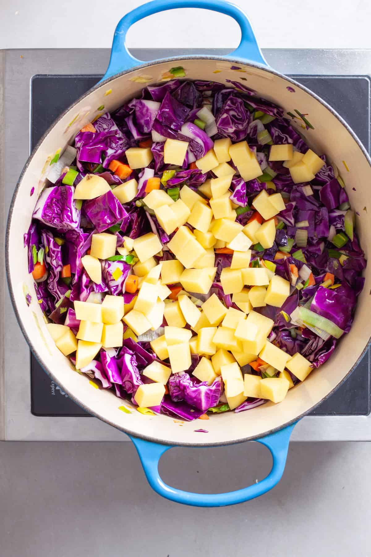 A chopped gold potato added to a hearty red cabbage soup.