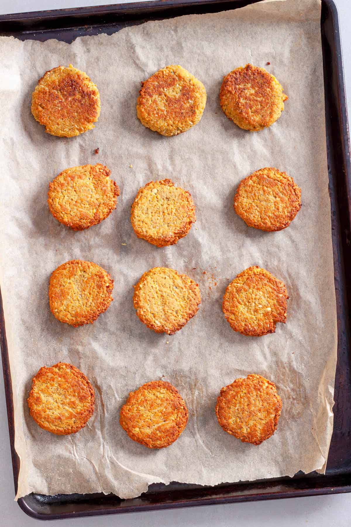 Cooked red lentil patties on a parchment lined baking sheet.