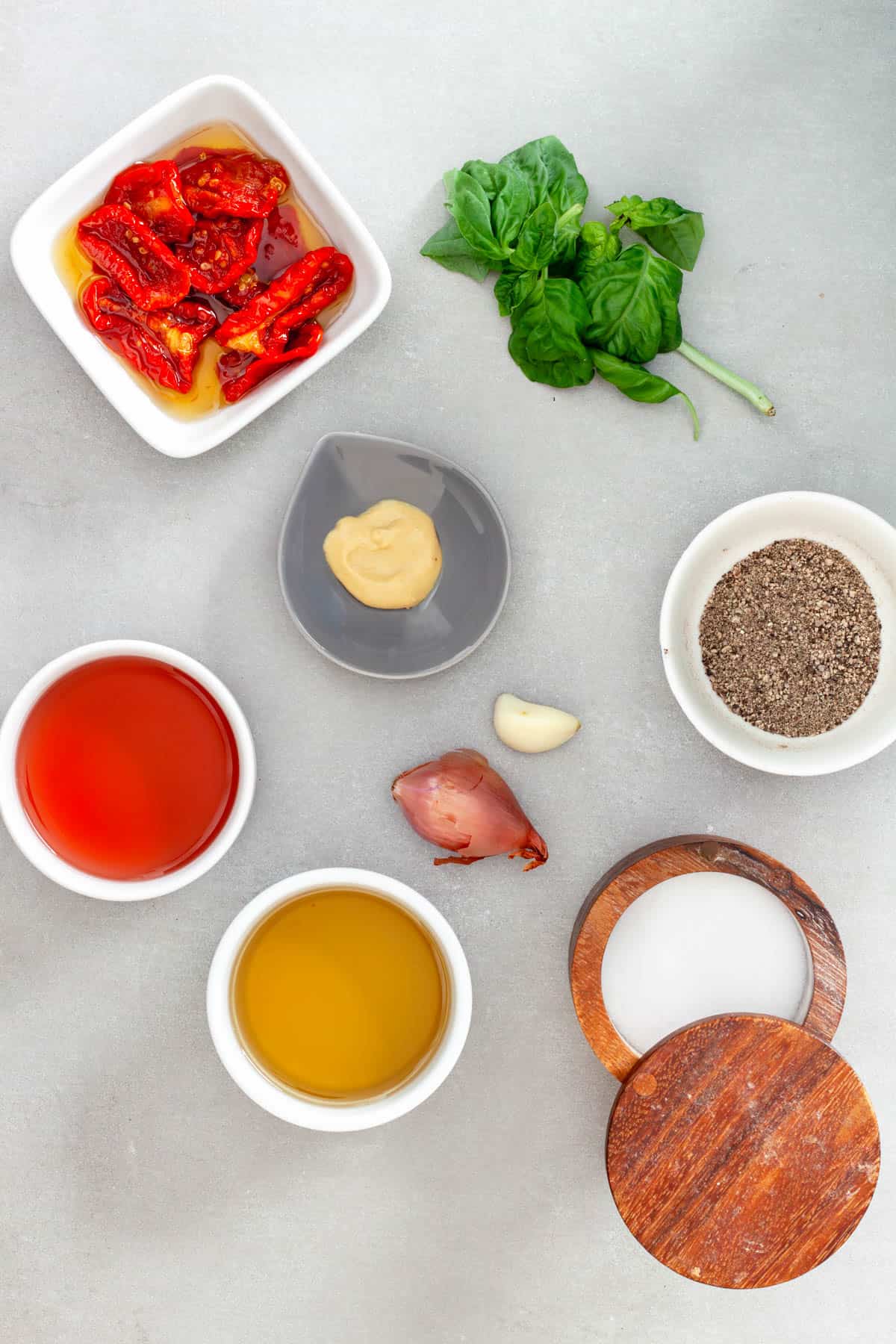 Ingredients for a homemade sun-dried tomato dressing on a gray table.