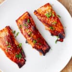 A platter of miso salmon topped with scallions and sesame seeds.