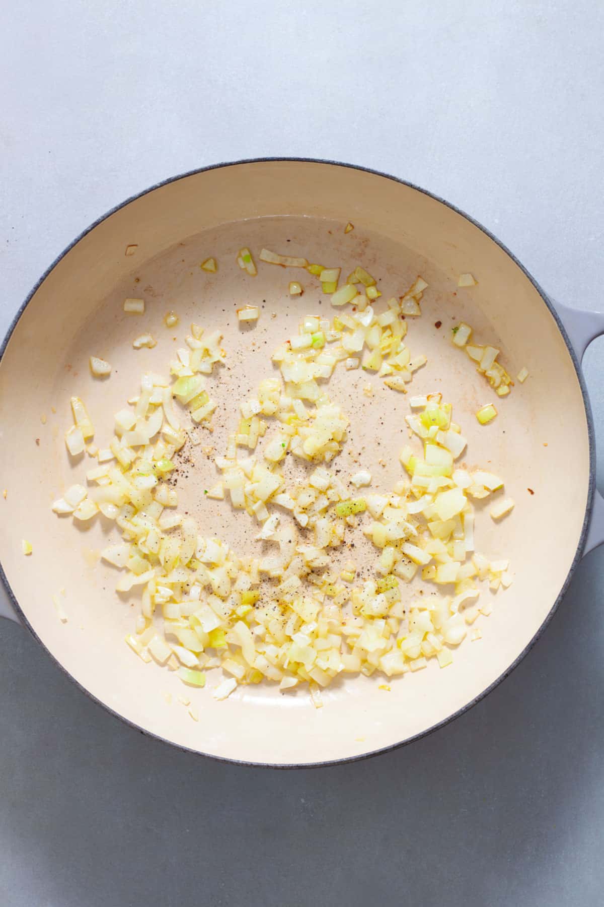 Chopped onions cooking in a large skillet.