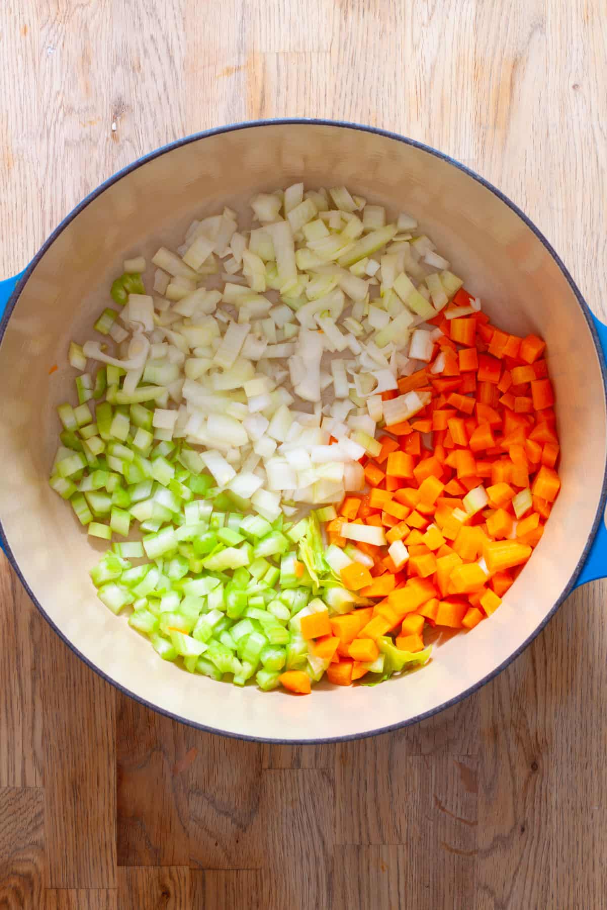 Chopped onion, celery and carrots in a large Dutch oven ready to get cooked.