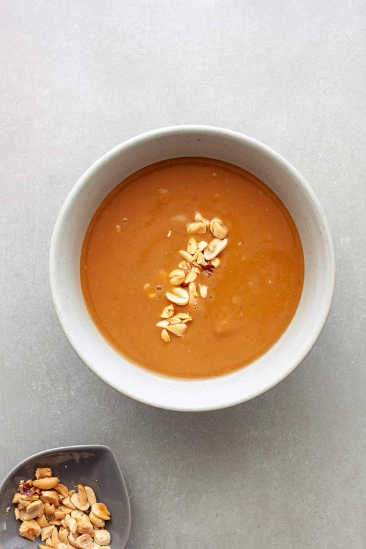 Vietnamese peanut sauce in a bowl topped with chopped roasted peanuts.