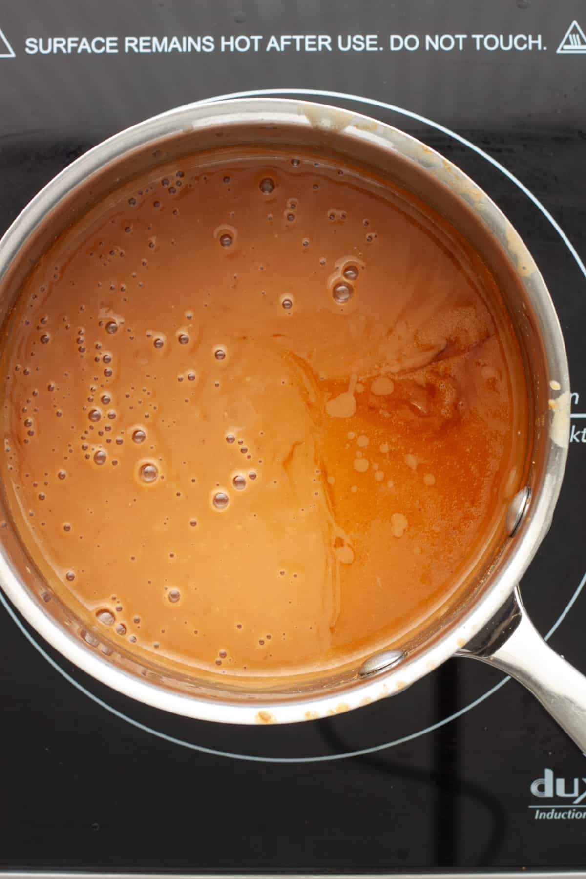 Peanut sauce simmering in a small saucepan.