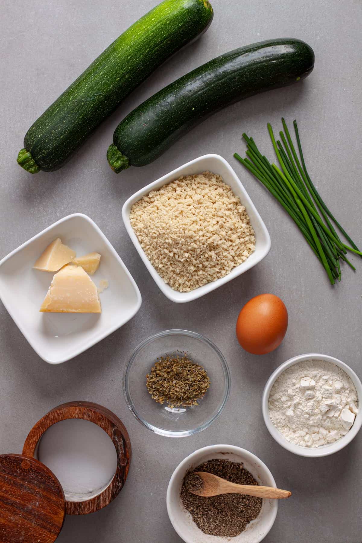 Ingredients for air fryer zucchini fritters on a gray table.