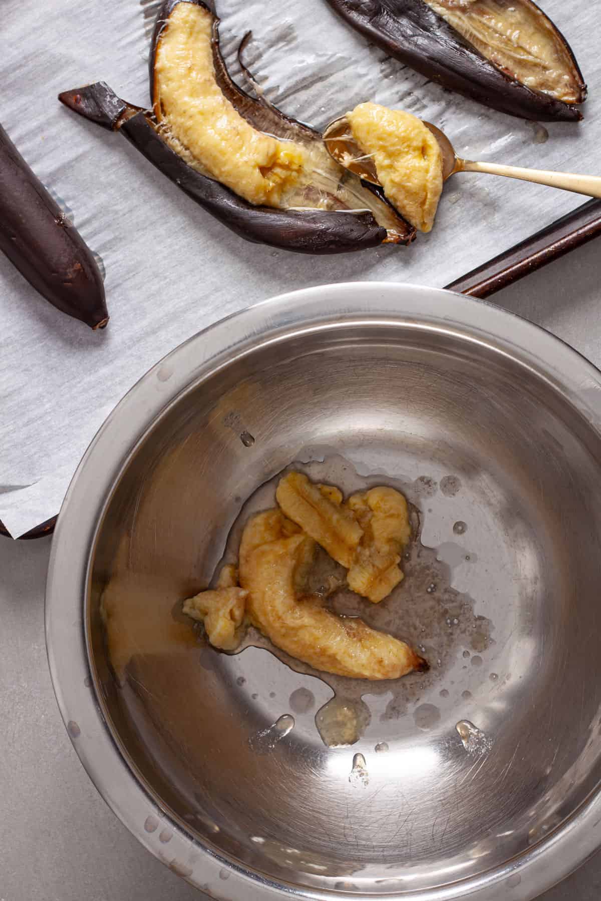 Roasted bananas added to a mixing bowl.